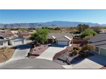 Stunning aerial view of a single-story home with a well-maintained yard and beautiful mountain views in the distance at 5480 Lincolnwood Ct, Pahrump, NV 89061