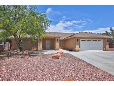 Charming single-story home featuring mature tree, desert landscaping, and neutral stucco exterior at 5480 Lincolnwood Ct, Pahrump, NV 89061