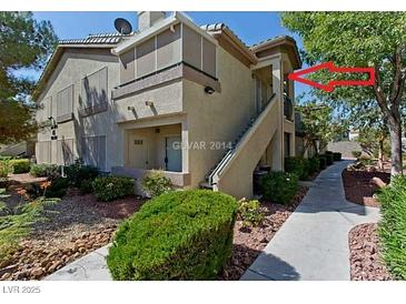 View of the exterior of the home featuring tan stucco, a walkway, and mature landscaping at 5710 E Tropicana Ave # 2178, Las Vegas, NV 89122