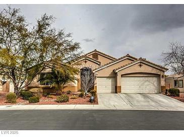 Charming single-story home featuring a well-manicured front yard and a two-car garage at 6712 Tattler Dr, North Las Vegas, NV 89084
