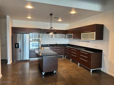 Modern kitchen boasts stainless steel appliances, dark wood cabinetry, and a center island at 900 Las Vegas Blvd # 1003, Las Vegas, NV 89101