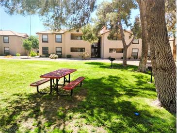 Apartment building with picnic tables in a grassy communal area, creating an inviting outdoor space at 2451 N Rainbow Blvd # 2073, Las Vegas, NV 89108