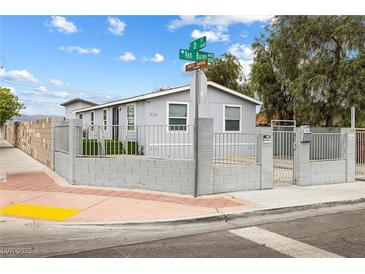 Charming single-story home featuring a secure fenced yard, freshly painted exterior, and manicured landscaping at 320 W Van Buren Ave, Las Vegas, NV 89106