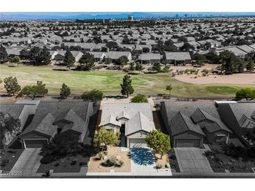 An aerial view of single-story home with desert landscaping and golf course, set within a suburban neighborhood at 3405 Kingbird Dr, North Las Vegas, NV 89084