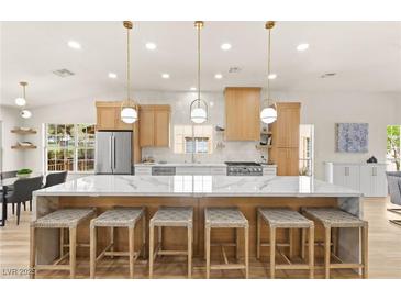 Bright, updated kitchen with island seating, modern appliances, and stylish pendant lighting at 5157 Future Dr, Las Vegas, NV 89130