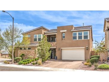 Two-story home with tan exterior, stone accents, manicured landscaping, and a two-car garage at 9655 Skye Star Ave, Las Vegas, NV 89166