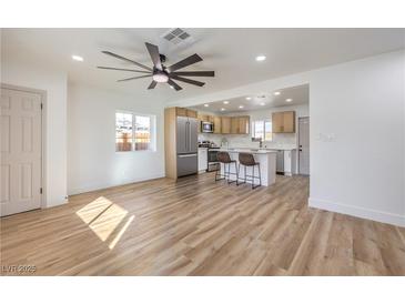 Open-concept living room features modern ceiling fan, wood floors, and adjoins kitchen for seamless entertaining at 1209 S 17Th St, Las Vegas, NV 89104