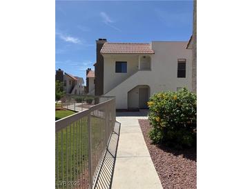 Inviting two-story condo featuring well-maintained landscaping, and a pathway to the front door at 2212 Sunfish Dr # D, Henderson, NV 89014