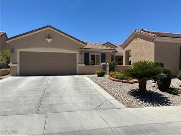 Charming single-story home featuring a desert landscape, two-car garage, and neutral-toned stucco exterior at 2365 Wisconsin Dells Dr, Henderson, NV 89044
