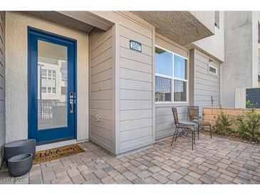 Inviting front entrance featuring a bright blue door and charming outdoor seating area at 2507 Silent View Ave, Henderson, NV 89044