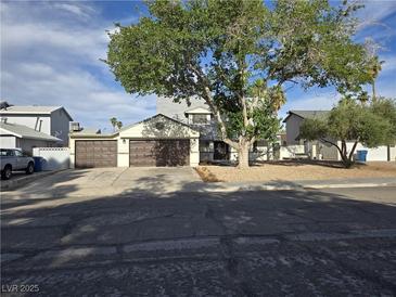 Charming two-story home featuring a three-car garage, mature tree, and low-maintenance landscaping at 3056 Garnet Ct, Las Vegas, NV 89121