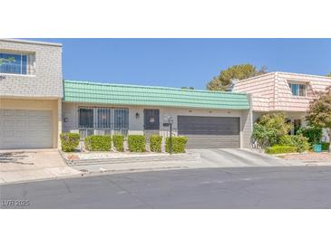 Charming single-story home featuring a green tile roof and well-manicured front yard landscaping at 3815 Atlantis St, Las Vegas, NV 89121