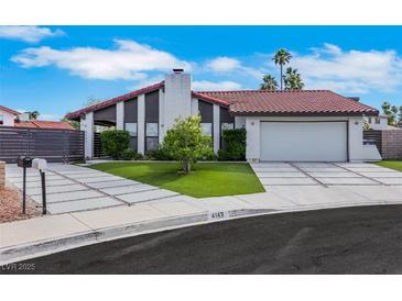 Charming single-story home featuring a red tile roof, modern driveway, and lush landscaping at 4143 Chela Cir, Las Vegas, NV 89120