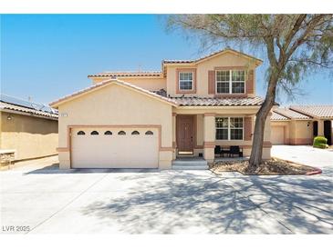 Inviting two-story home with a desert landscape, large driveway, and a charming front porch seating area at 561 Fork Mesa Ct, Henderson, NV 89015