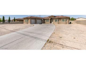 Spacious desert home featuring a long driveway and three-car garage, perfect for car enthusiasts at 6131 Rio Vista St, Las Vegas, NV 89130