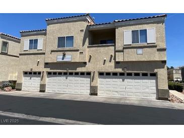 Three-story condo with individual one car garages and neutral colored facade under a bright blue sky at 6170 E Sahara Ave # 1012, Las Vegas, NV 89142