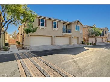 Charming townhome showcases a three car garage and neutral stucco exterior under a bright blue sky at 6255 W Arby Ave # 258, Las Vegas, NV 89118