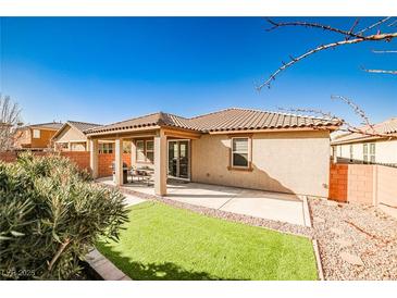 A backyard with an inviting covered patio and a small patch of artificial turf at 766 Topocoba St, Las Vegas, NV 89178