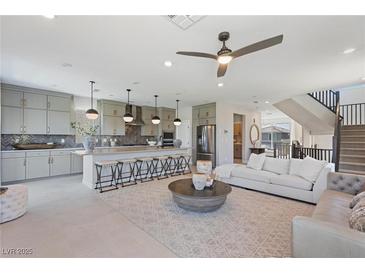 Open-concept living room showcases seamless flow to the kitchen, complemented by modern furnishings and stylish decor at 7983 Texas Hills St, Las Vegas, NV 89113