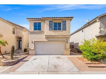 Charming two-story home featuring a two-car garage and low-maintenance desert landscaping under a bright blue sky at 10642 Dawns Mist Ave, Las Vegas, NV 89129
