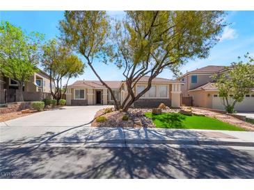 Charming single-story home with desert landscaping, mature shade trees, and a spacious driveway at 1387 Minuet St, Henderson, NV 89052
