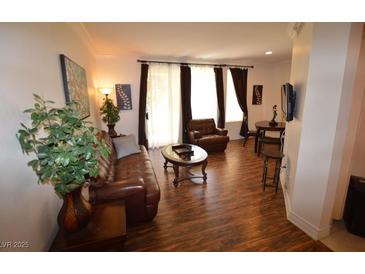 Inviting living room featuring hardwood floors, comfortable seating, and natural light from the windows at 230 E Flamingo Rd # 129, Las Vegas, NV 89169