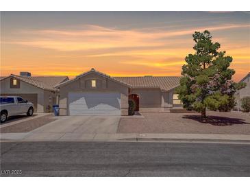 Charming single-story home with a well-maintained front yard and a two-car garage at sunset at 394 Lombardy Cir, Henderson, NV 89015