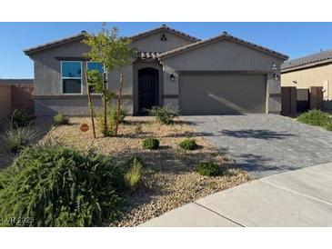 Charming single-story home with xeriscaped front yard and paver driveway, presenting modern curb appeal at 411 Hellebores Ave, North Las Vegas, NV 89084