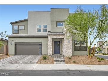 A modern two-story home with a gray exterior, complemented by a stone entrance and well-maintained landscaping at 6830 Fallen Rock St, North Las Vegas, NV 89084