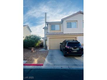 Two story home featuring drought resistant front yard, two-car garage, and covered entryway at 779 Peregrine Falcon St, Henderson, NV 89015