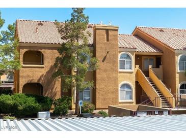 Charming condo showcasing classic architecture, stairs to the units, and well-maintained landscaping at 7950 W Flamingo Rd # 1077, Las Vegas, NV 89147