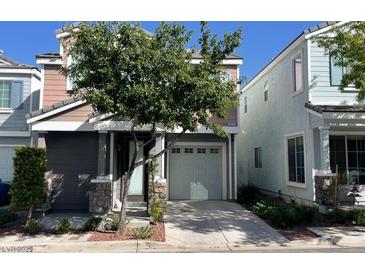 Contemporary two-story home featuring a two-car garage, stone accents, and a well-maintained front yard at 8218 Golden Flowers St, Las Vegas, NV 89139