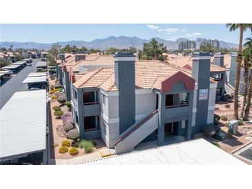 Low-rise condo building featuring red tile roof and neutral grey paint against mountain backdrop at 8600 W Charleston Blvd # 2068, Las Vegas, NV 89117