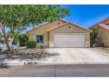 Charming single-story home featuring a two-car garage, desert landscaping, and a welcoming facade at 8934 Libertyvale Dr, Las Vegas, NV 89123