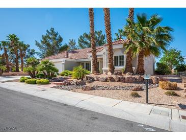 Charming single-story home with a well-manicured front yard and desert landscaping with palm trees at 9524 Quail Ridge Dr, Las Vegas, NV 89134