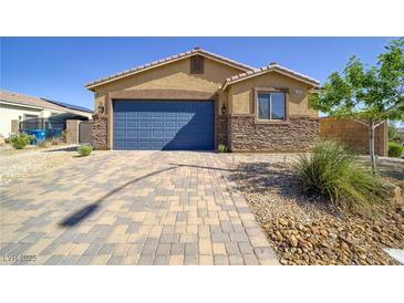 Charming single-story home featuring a stone facade, well-manicured landscaping, and a two-car garage at 2099 Port Royal Dr, Laughlin, NV 89029