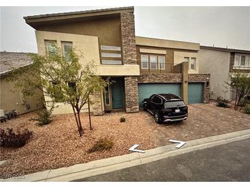Contemporary two-story home with a stone facade, two-car garage, and xeriscaped front yard at 8738 Stella Nova St, Las Vegas, NV 89139