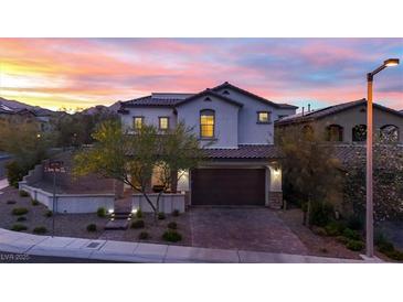 Charming two-story home with a tile roof and a well-manicured front yard against a colorful sunset backdrop at 11856 Barona Mesa Ave, Las Vegas, NV 89138