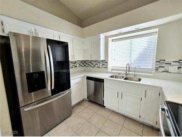 Bright kitchen featuring stainless steel appliances, white cabinetry, and a modern backsplash at 2035 E Warm Springs Rd # 1017, Las Vegas, NV 89119