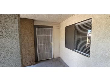 A secure front door with a security screen door and a window located to the right side at 3151 Soaring Gulls Dr # 1074, Las Vegas, NV 89128