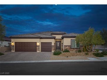 Charming single story home with a desert landscape, two car garage, and stone accents at dusk at 5234 Savannah Rose St, Las Vegas, NV 89149