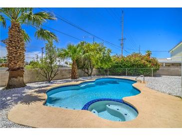 Inviting in-ground pool with a spa surrounded by lush landscaping and a white gravel perimeter at 5279 Consul Ave, Las Vegas, NV 89142