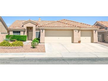 Charming home with a three-car garage and well-maintained front yard at 5704 Owl Butte Ct, Las Vegas, NV 89149