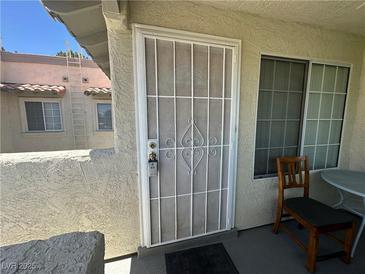 Welcoming entryway featuring a secure metal security door and a quaint seating area next to a bright window at 6804 Elm Creek Dr # 202, Las Vegas, NV 89108