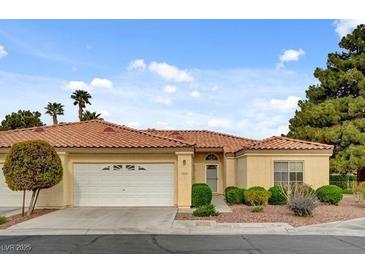 Inviting single-story home featuring a red tile roof, lush landscaping, and an attached two-car garage at 7232 Vista Bonita Dr, Las Vegas, NV 89149