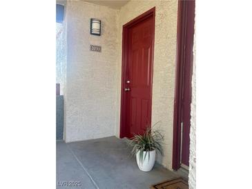 Condo front door with red finish, house number, and exterior light fixture at 8600 W Charleston Blvd # 2033, Las Vegas, NV 89117