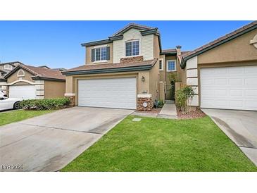 Charming two-story townhome with a two-car garage, stone accents, and a well-maintained lawn at 10311 Birch Bluff Lane Ln, Las Vegas, NV 89145
