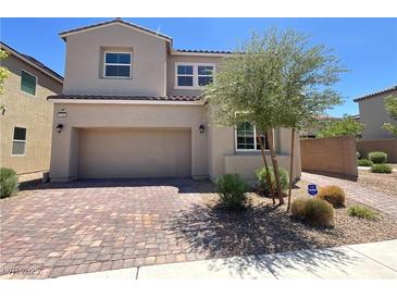 Charming two-story home showcasing neutral stucco, brick driveway, and a well-manicured front yard at 2125 Stone Well Rd, North Las Vegas, NV 89031