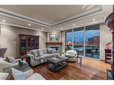 Elegant living room featuring hardwood floors, fireplace, and floor-to-ceiling windows with stunning city views at 2877 Paradise Rd # 2602, Las Vegas, NV 89109