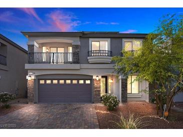 Charming two-story home boasts a stone facade, a two-car garage and a cozy second-story balcony at 6618 Tangled Vines Ave, Las Vegas, NV 89139